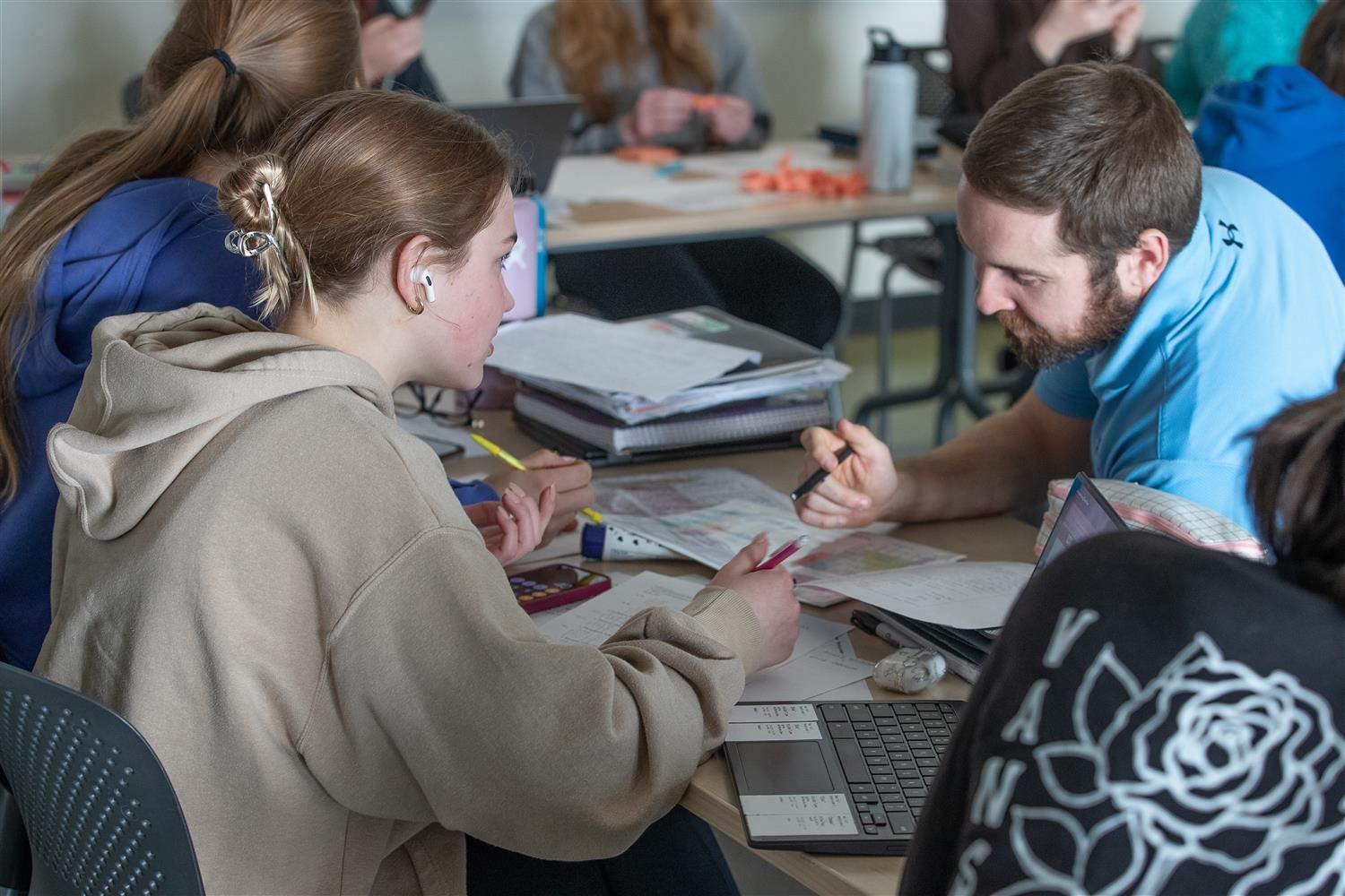  classroom teacher and student going over assignment